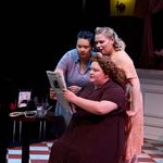 Photo: Three women in a theater production onstage in costumes