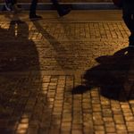 Photo: A shadow of a person walking on brick pavement