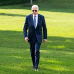 Photo: Former president Joe Biden walking across a green lawn