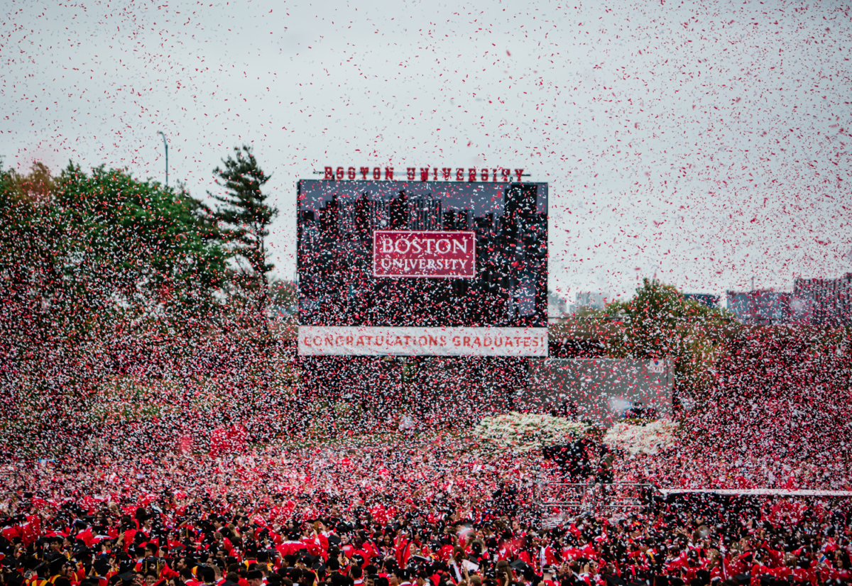 Photo: A sea of confetti over a large crowd of graduates in red gowns at the 2024 Boston University Commencement