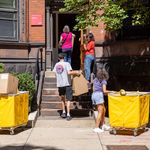 Photo: College students moving into a brownstone dorm on a sunny day