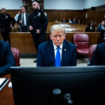 Photo: A man in a blue suit sits in a court room with a dejected look on his face. Former President Donald Trump awaits the start of proceedings during jury selection at Manhattan criminal court, Thursday, April 18, 2024 in New York. (Jabin Botsford/The Washington Post via AP, Pool)
