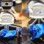 Photo: A robotic arm squishing a blue object used in military helmets to test its material properties