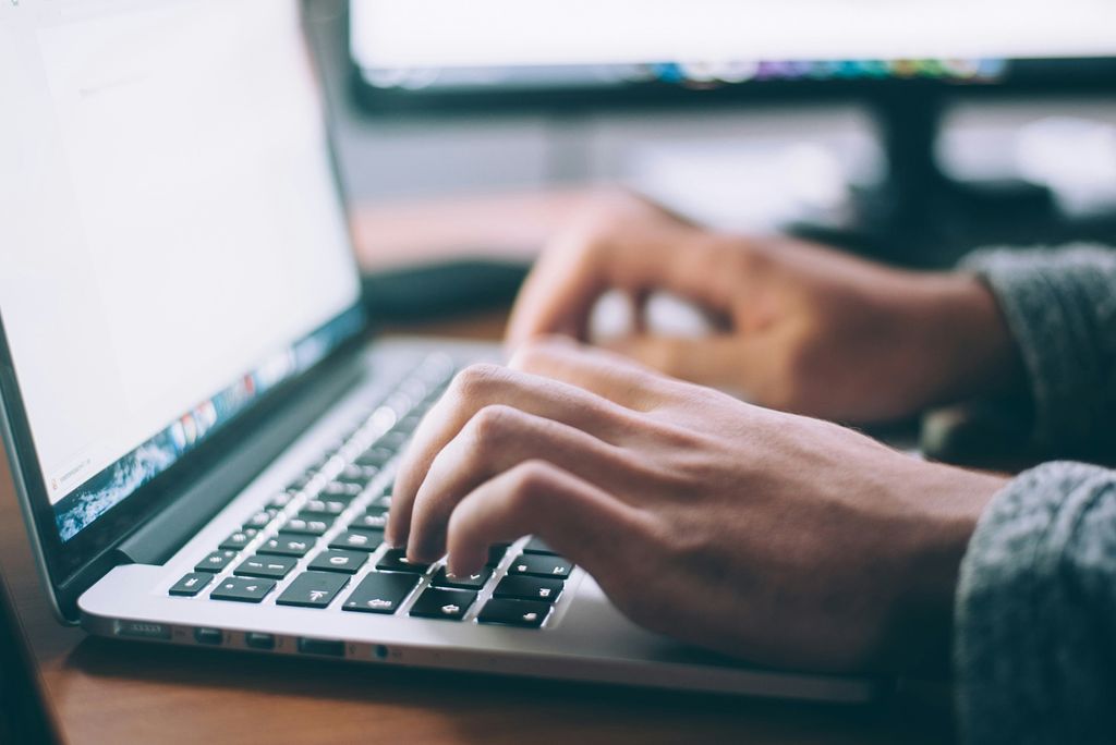 Photo: Person's hands typing on a laptop computer