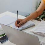 Photo: Person studying and writing notes on paper