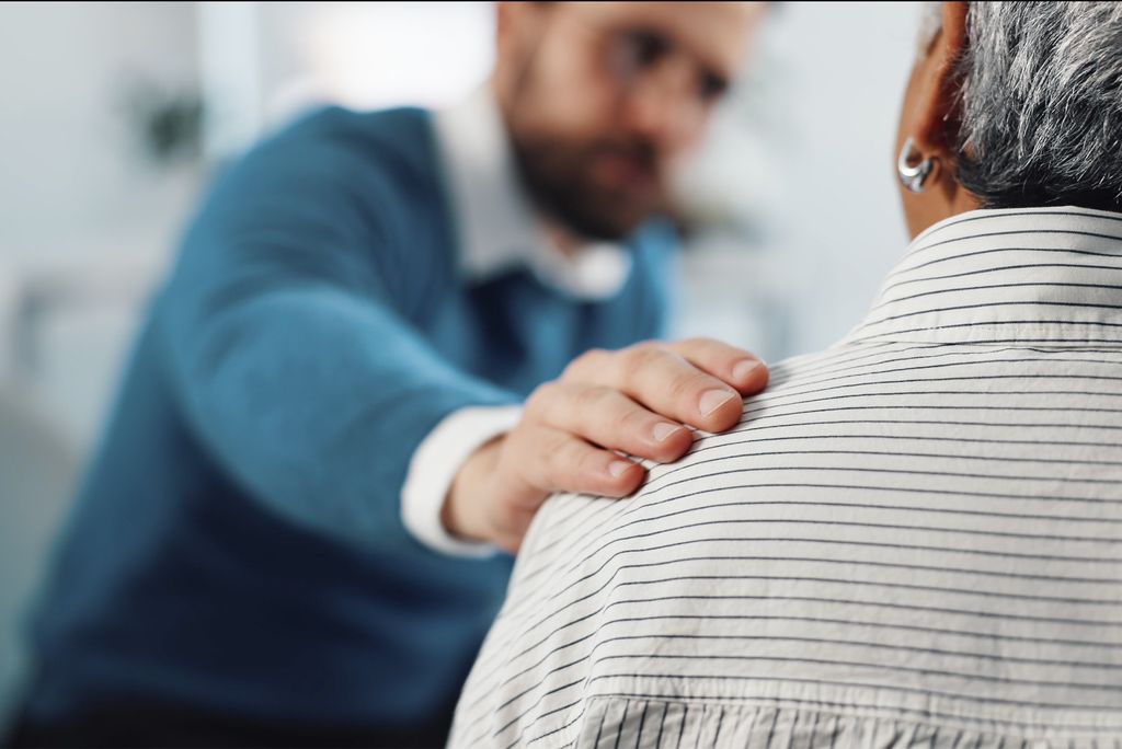 Photo: person placing their hand on another person's shoulder