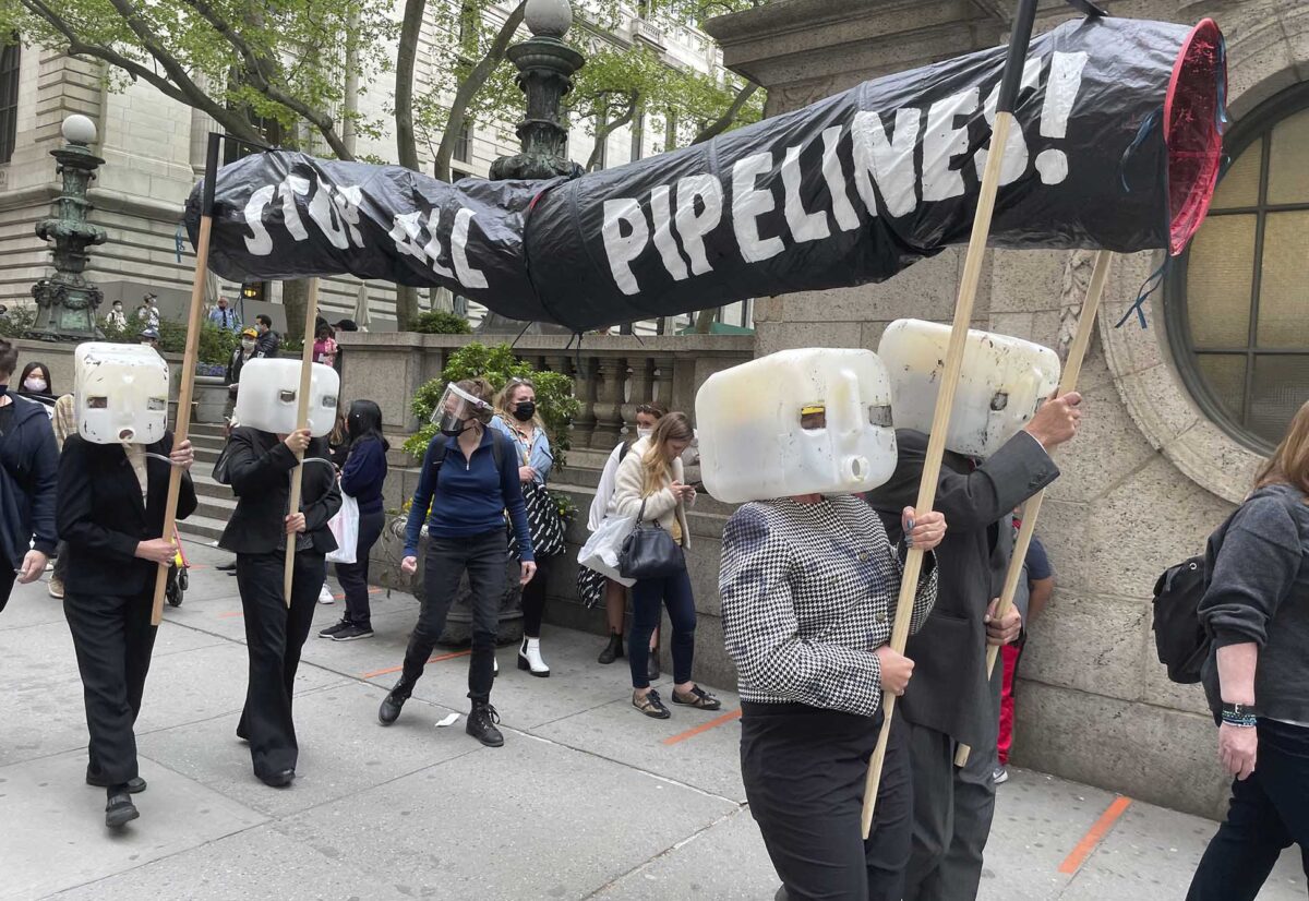 Photo: Environmentalists help bring an end to further construction of the Keystone XL oil pipeline project, which contributes to the use of fossil fuels linked to pollution, environmental degradation and global warming. They protest with plastic jugs on their heads and a paper pipe which reads STOP ALL PIPELINES.