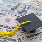 Photo: A pile of money with a graduation cap sitting on it