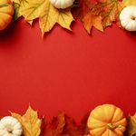 Photo: A red background with leaves and pumpkins surrounding the border