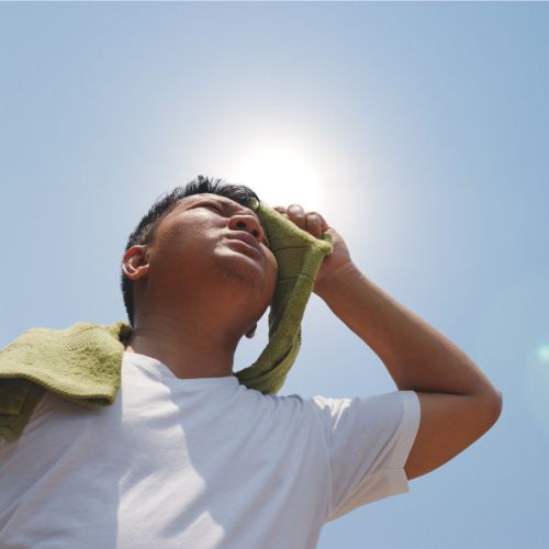Man wiping sweat from his forehead with a towel
