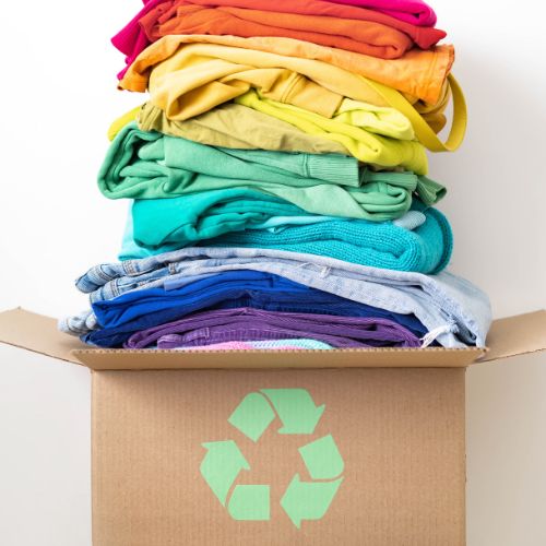 A brown box with a recycling symbol, full of colorful clothing