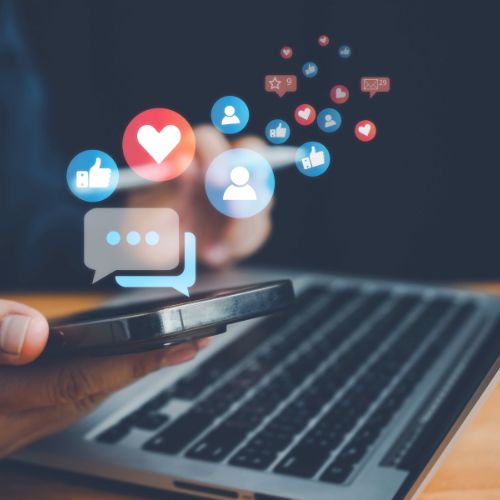 A phone and computer keyboard with like and follow logos on top