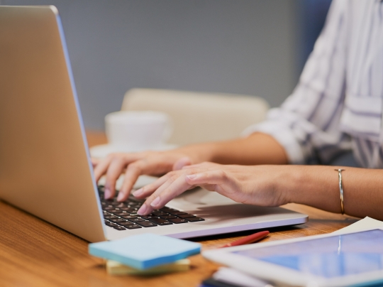 Person typing on a laptop keyboard.