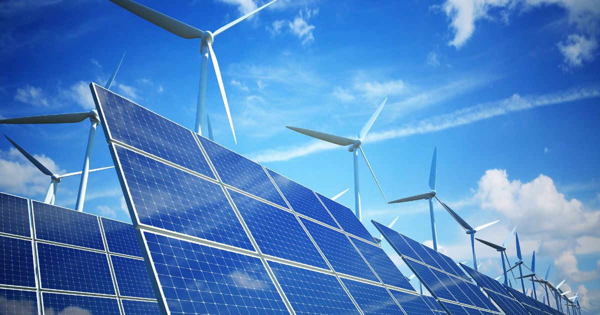 Wind turbines with solar panels in foreground.