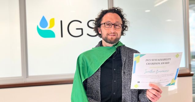 Jonathan Buonocore wears a green cape and holds a certificate.