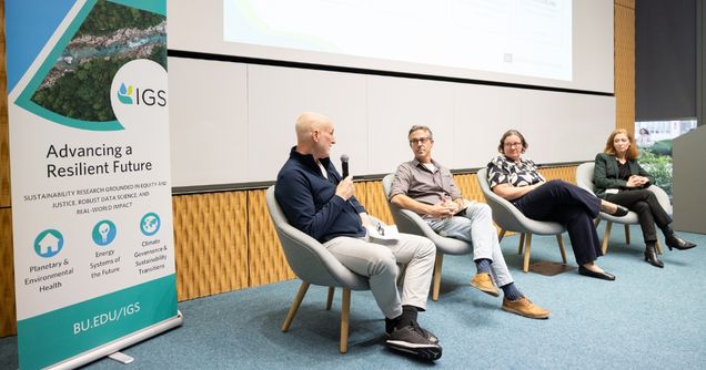 Fireside chat panelists seated in chairs discussing their research with attendees.