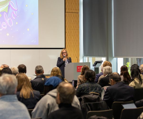 IGS Executive Director speaks at podium to audience.