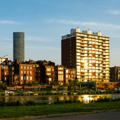 Sun shining on iconic Boston skyline buildings.