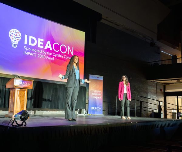 A student innovator presenting in front of audience