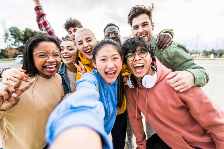Multiracial friends taking big group selfie shot