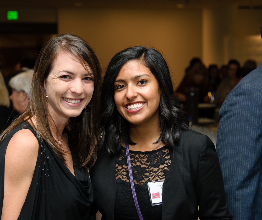Two alumni pose together at a reunion event