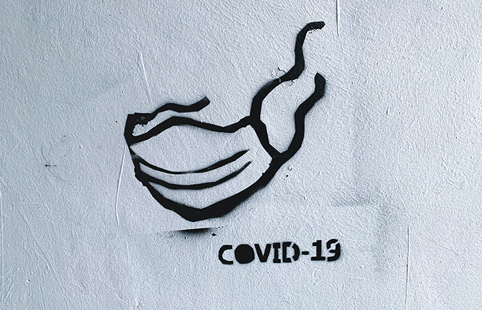 Graffiti of a surgical mask with COVID-19 underneath