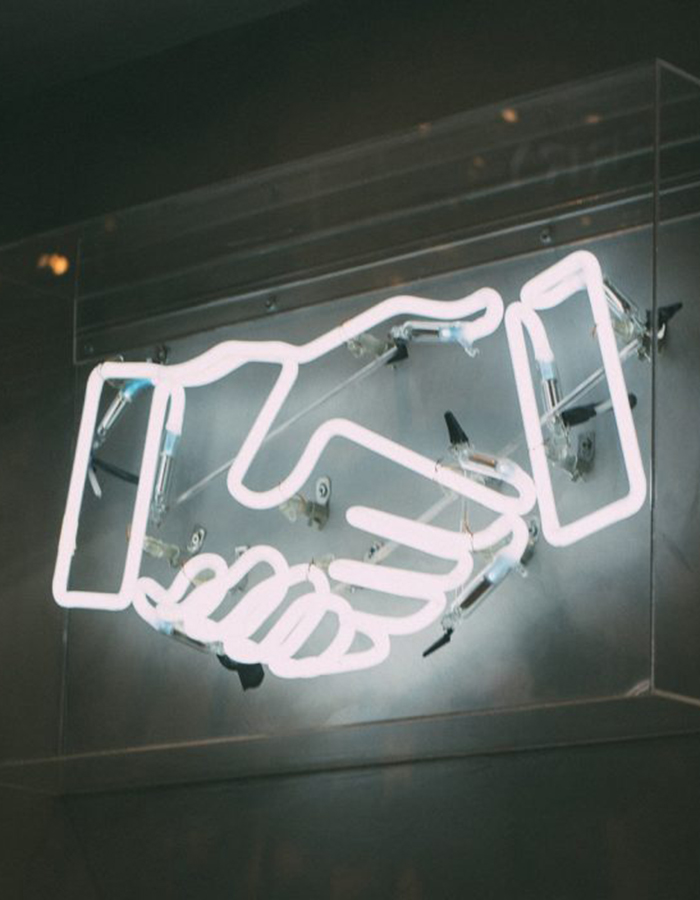 neon sign of a handshake