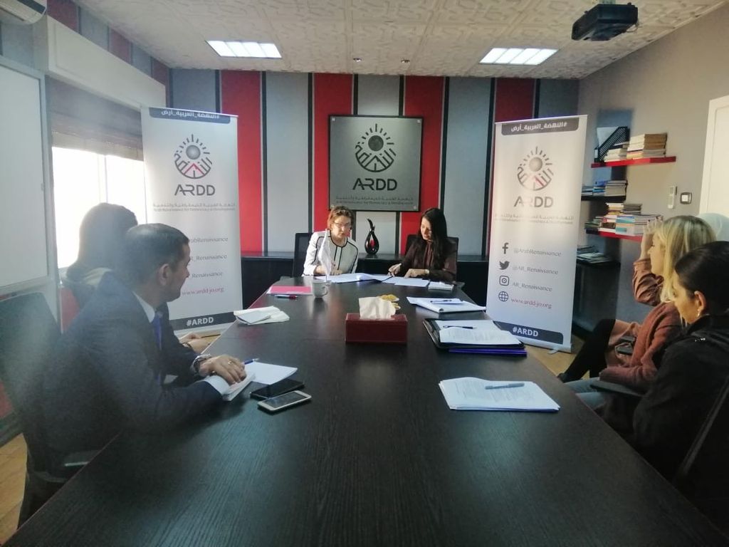 Group from ARDD and IHRC sit at a conference table during the workshop