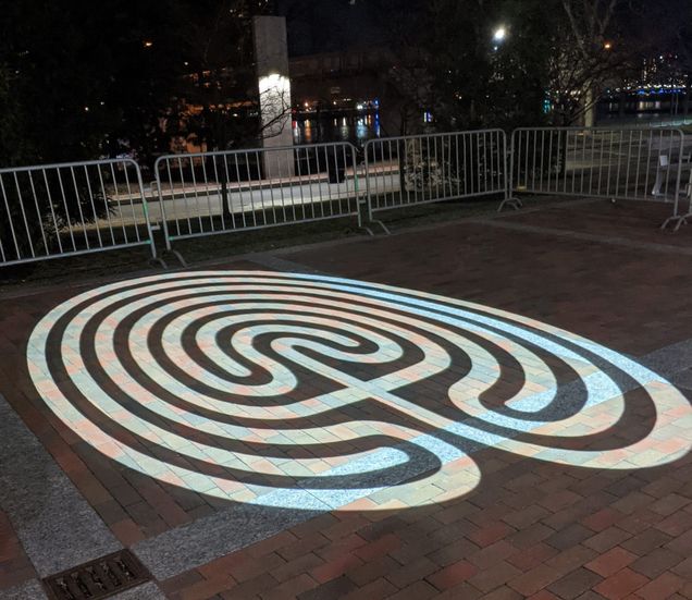 Closer view of light projected in the shape of a labyrinth at the law aud courtyard