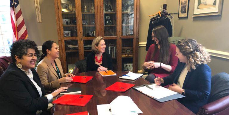 BU Law Professor Julie Dahlstrom and members of the coalition sit around a table discussing the bill.