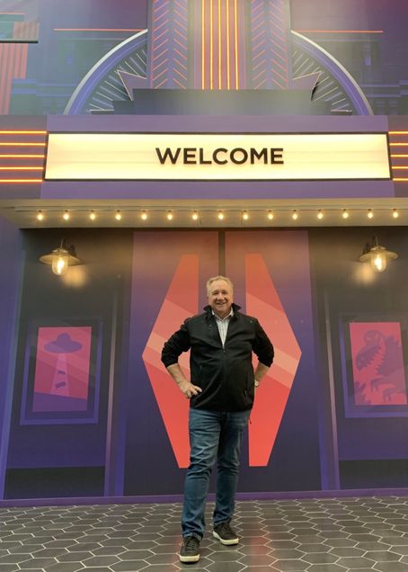 Steve Kay stands in front of the Roku headquarters, with a theater marquee that reads "Welcome."