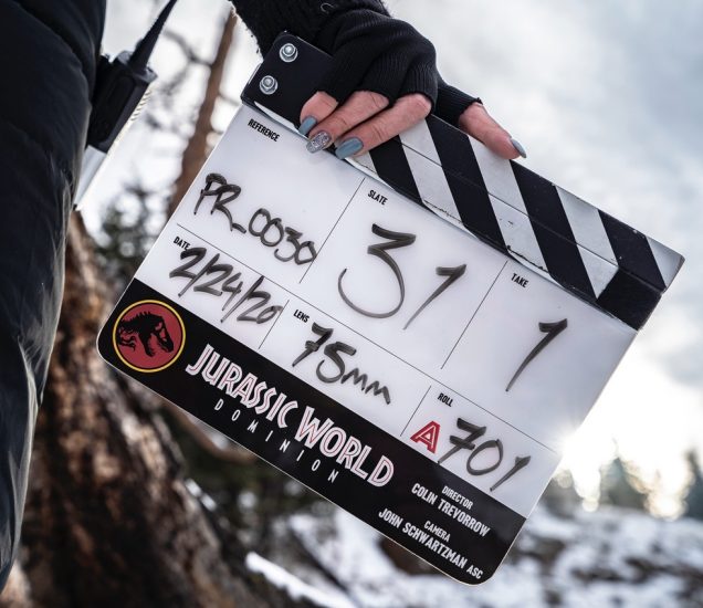 A color clapboard displays details of filming from Jurassic World Dominion