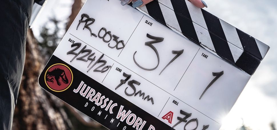 A color clapboard displays details of filming from Jurassic World Dominion