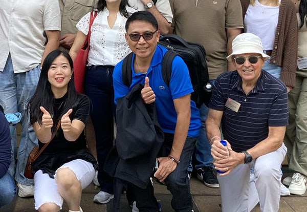 Professor Kevin Handly poses for a picture with students.