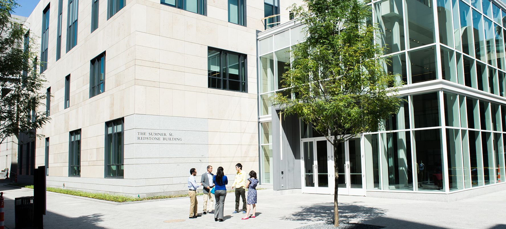 Exterior entrance to law complex with small group talking