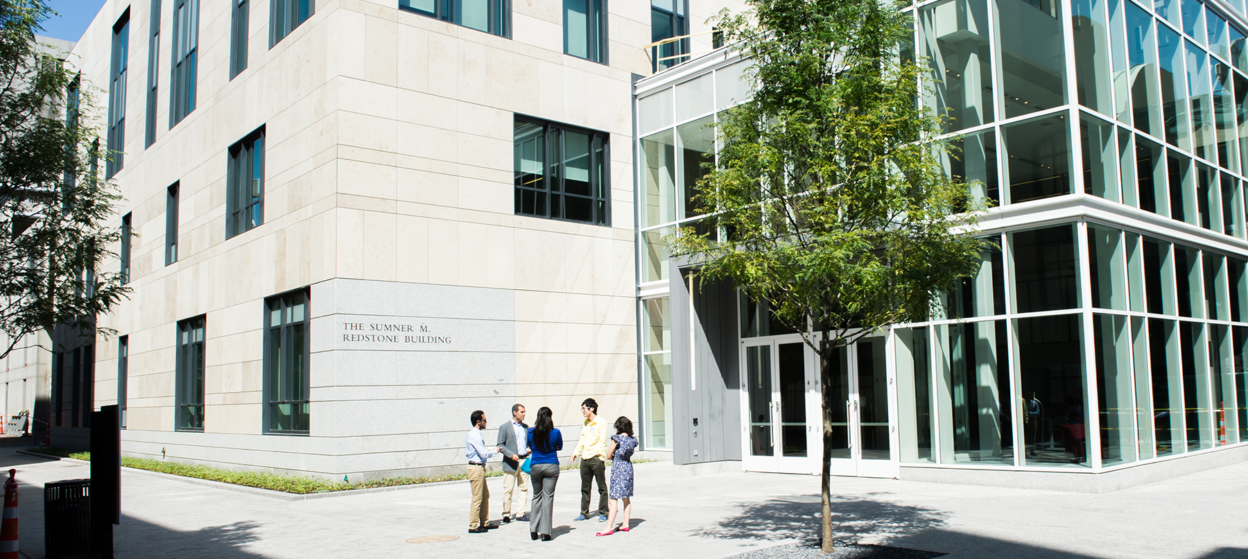 Exterior entrance to law complex with small group talking