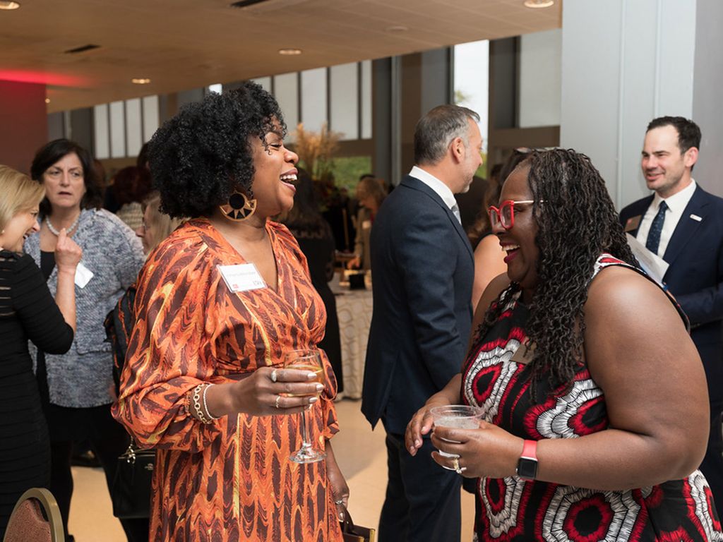 Kimberly Atkins Stohr ('98) and Dean Angela Onuwachi-Willig share a laugh at the BU Law 150th anniversary gala
