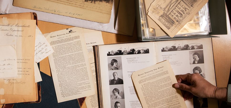 A group of documents from the BU Law archives, including an illustrated postcard of 11 Ashland Place, exams from the late 1800s, and a yearbook from 1922