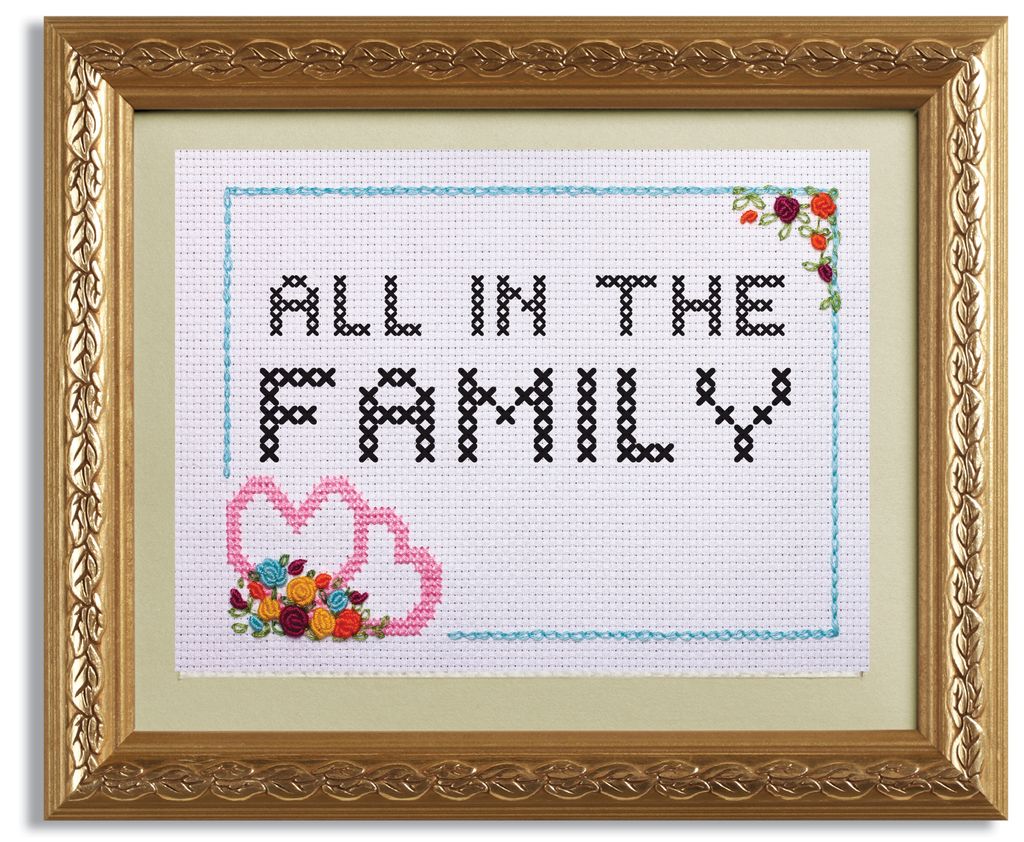 A framed cross-stitch reads "All in the Family"