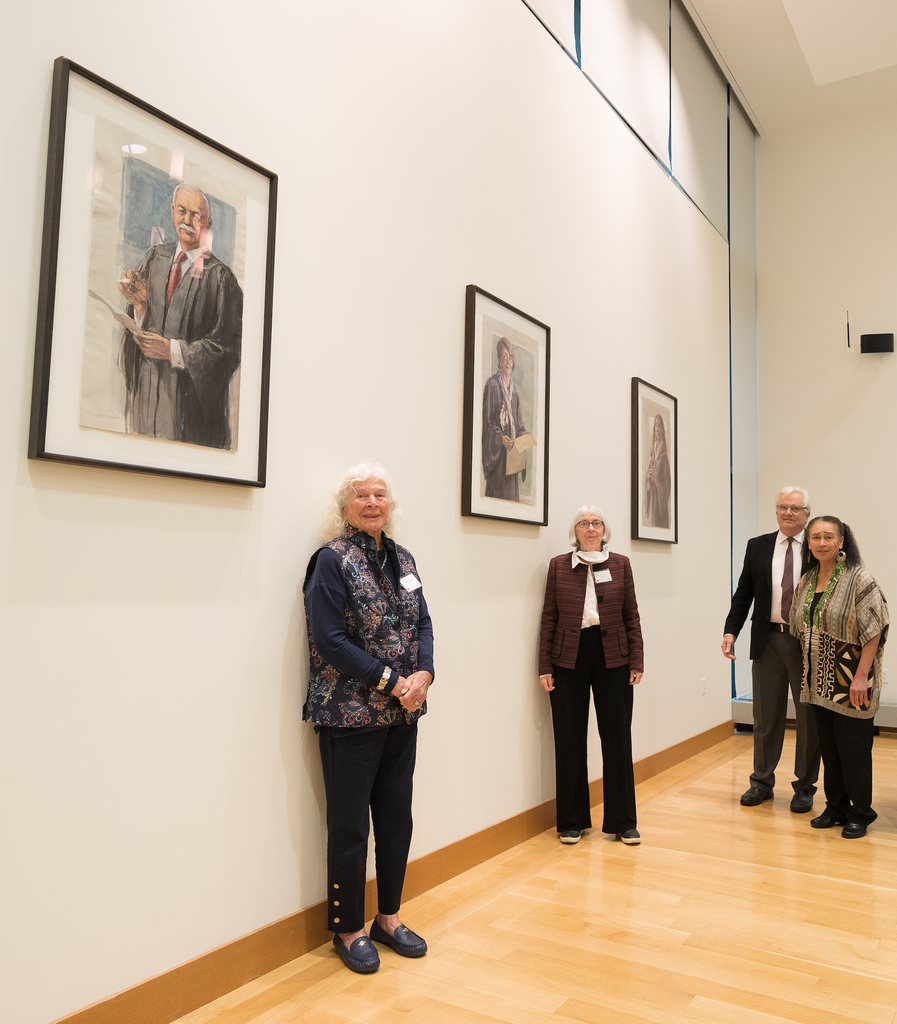 The wife of Juan R. Torruella ('57), Sandra Lynch ('71), and O. Rogeriee Thompson stand in front of their portraits alongside artist Timothy J. Clark.