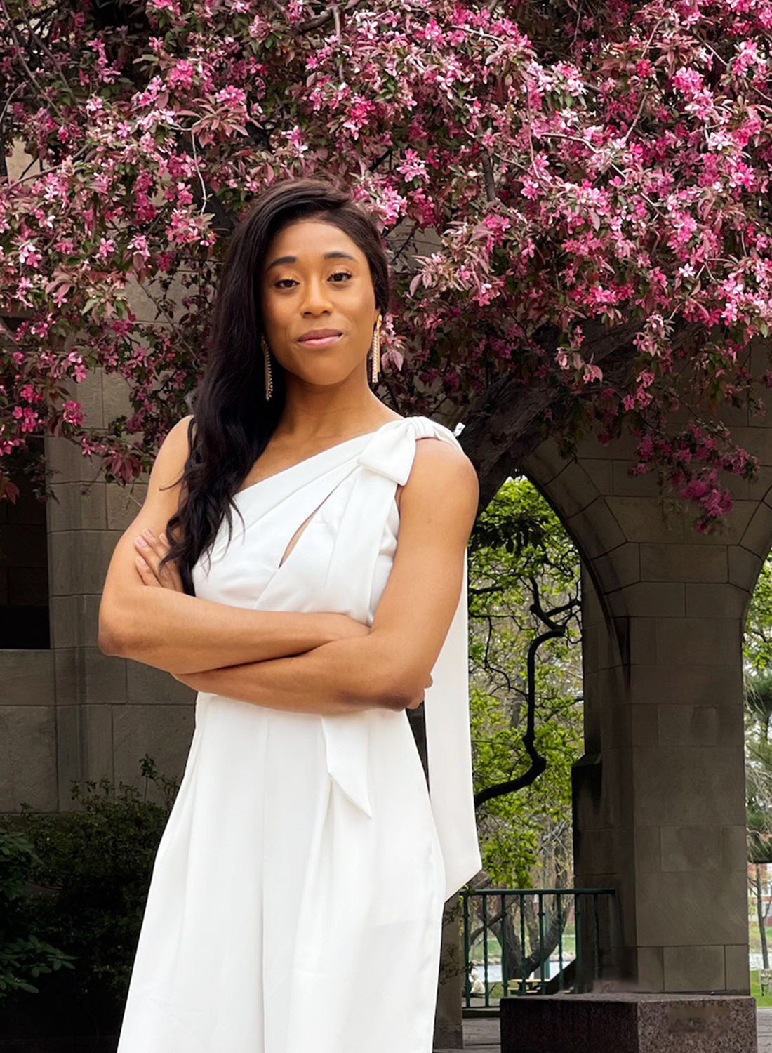 Kaye-Alese Green (LAW'25, MED'25) stands in front of a blooming tree on BU's campus