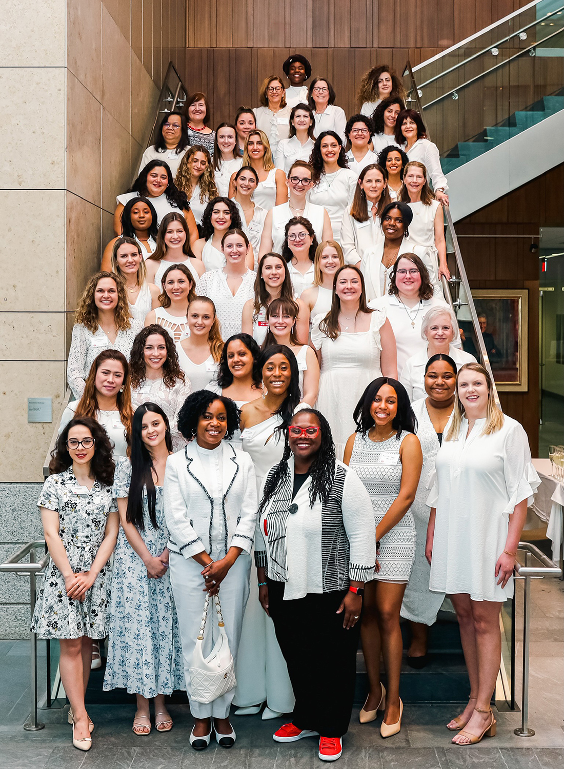 A group portrait of the attendees at the 2023 Women's Law Association end of year celebration on the steps in the Redstone building atrium