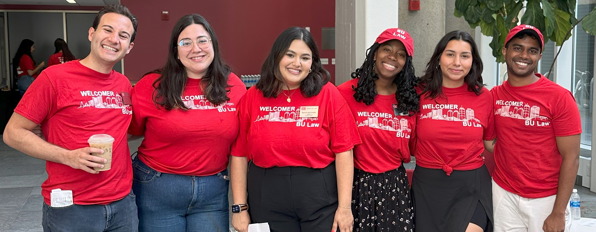 A group of 6 smiling BU Law students pose for a picture in the atrium.
