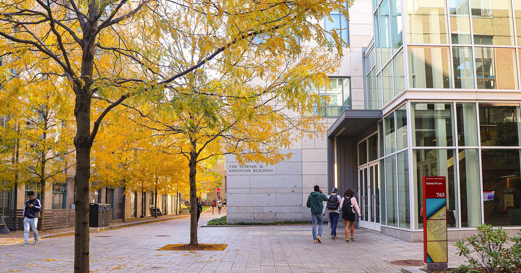 Students walk into the law complex on a fall day.