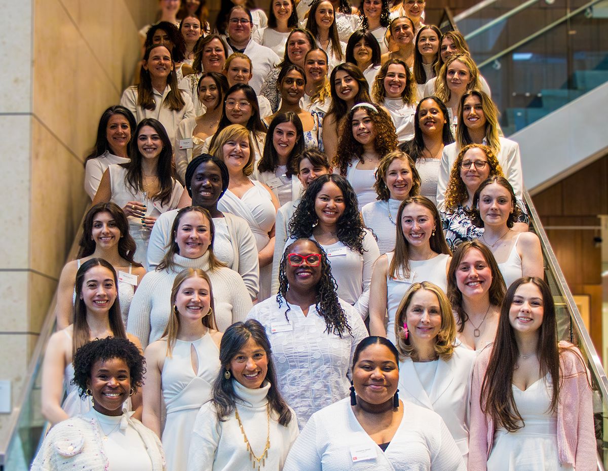 A group portrait of the attendees at the 2024 Women's Law Association end of year celebration on the steps in the Redstone building atrium