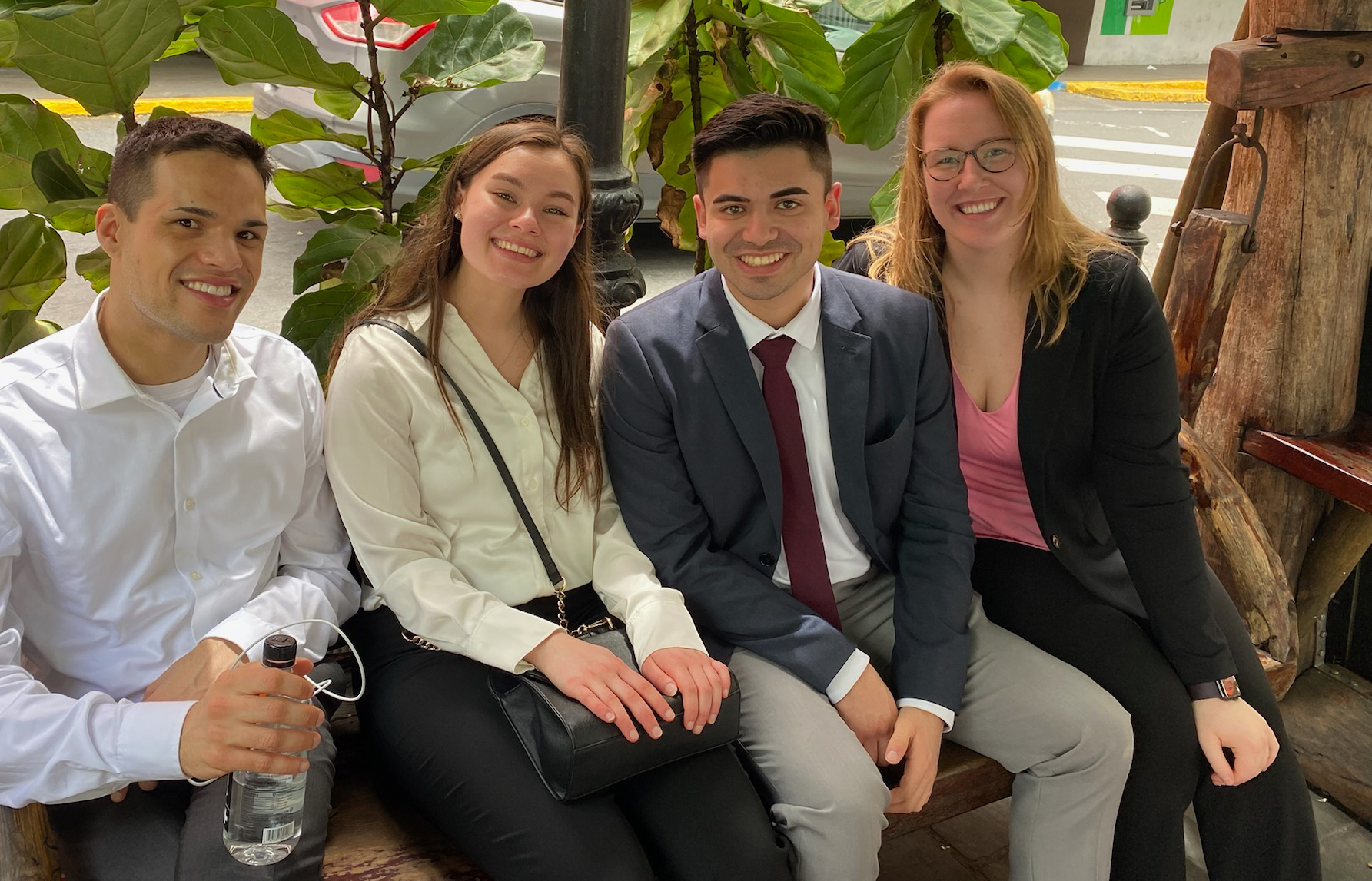 Four students in business attire pose for a picture while on a trip to Puerto Rico.