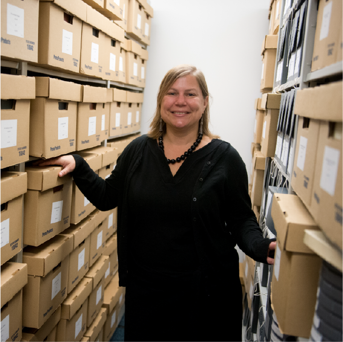 photo of Giordana Mecagni with archival collections boxes and materials