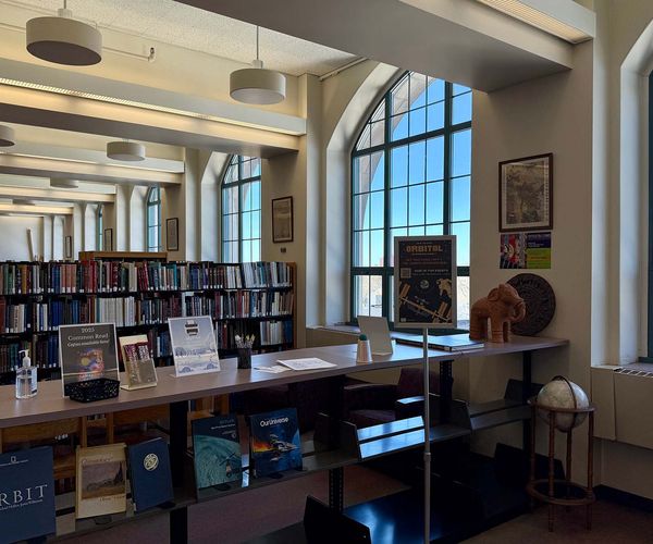 Tall windows and rows of bookshelves in the Stone Science Library.