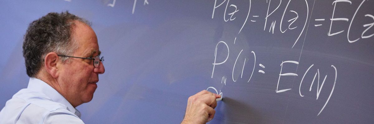MET Professor Hal Tepfer writing functions on a chalkboard