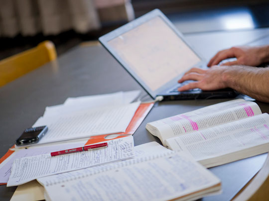 A table with a laptop and papers to indicate payment deadlines